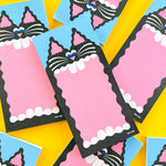 A pile of notepads with a big mouthed black cat designed by YUK FUN