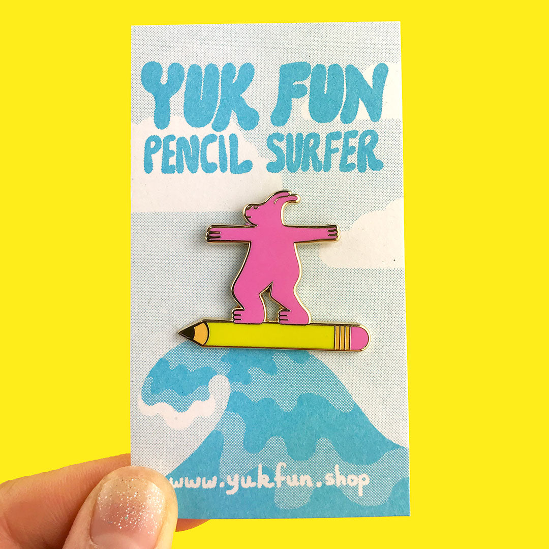 Cute pink pencil surfer dude enamel pin by YUK FUN