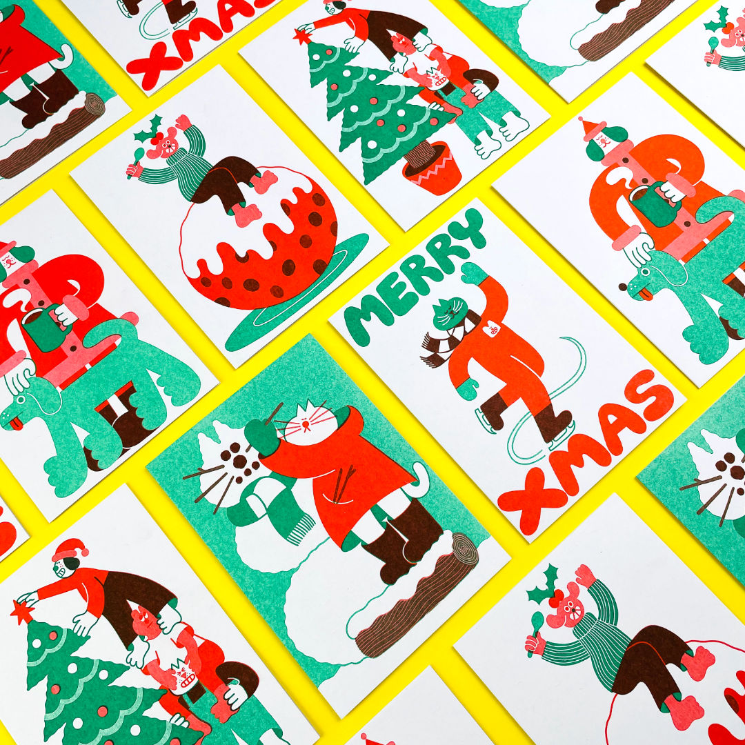 A diagonal flatlay of Christmas cards in red, green and brown on a yellow background.
